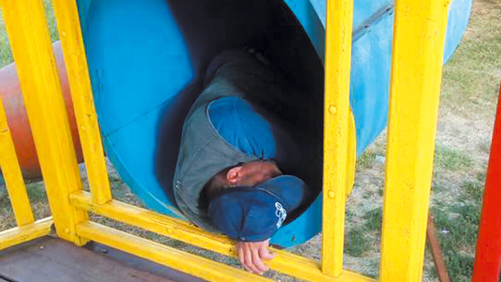 Un om al străzii, fotografiat în timp ce dormea în toboganul din Parcul Personalităţilor