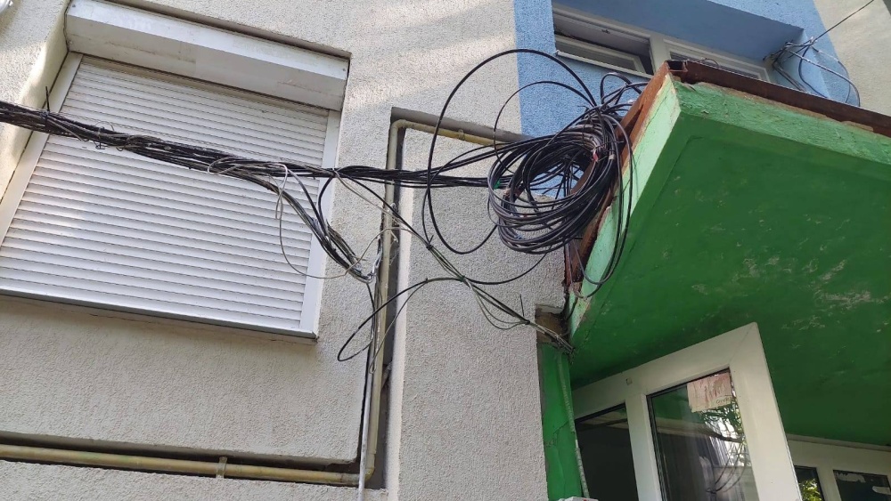 Cablurile fără stăpân atârnate de blocurile din municipiu, în atenţia consilierilor locali
